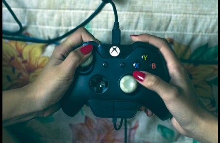 unas manos de mujer cogen un mando de juego